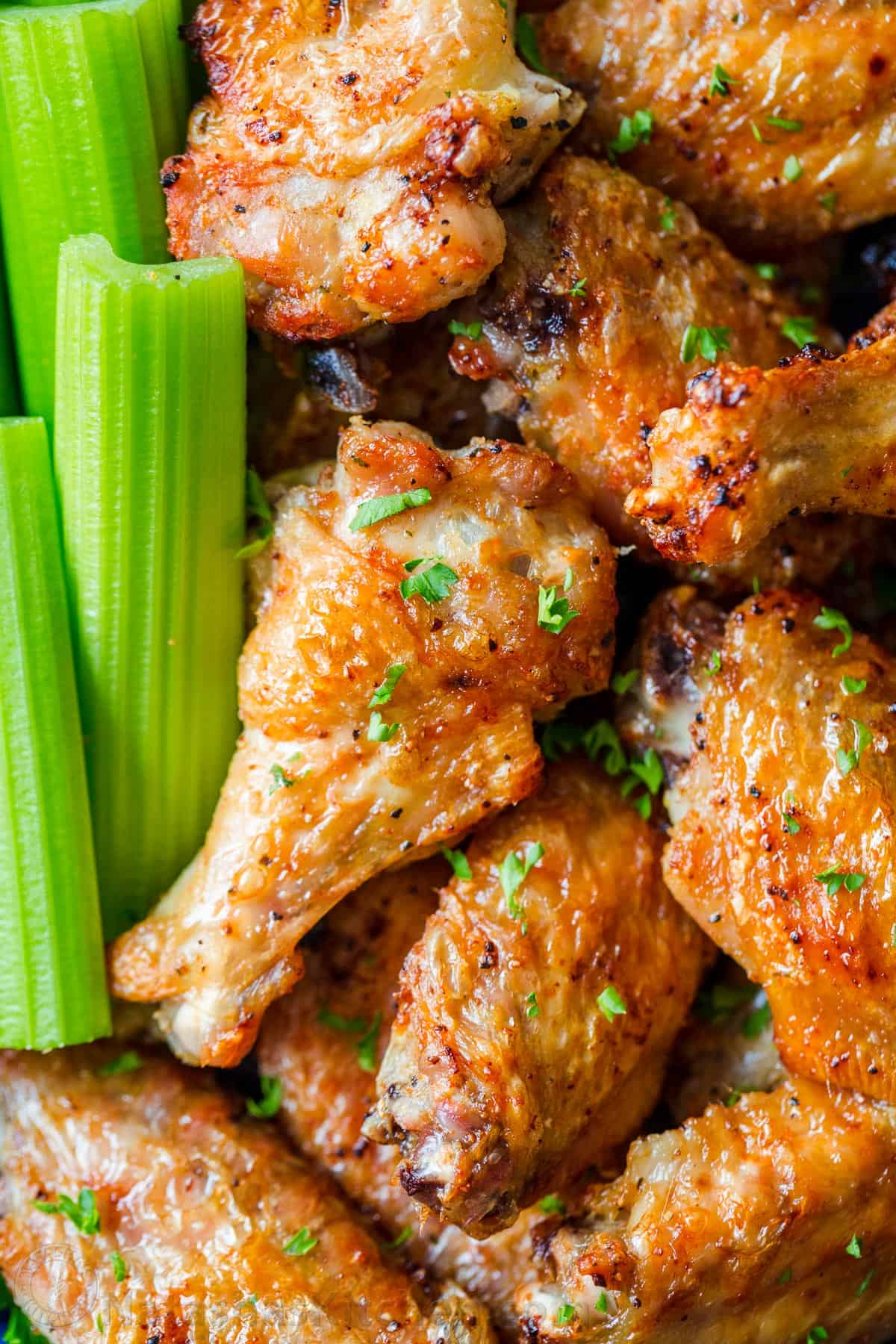 Air Fryer Chicken Wings with crisp salty skin, perfectly seasoned with garlic and lemon pepper. Air fried chicken wings cook so fast with no marinating! #airfryer #airfryerchicken #airfryerchickenwings #chickenwings #crispchickenwings #chicken #airfryerrecipes #natashaskitchen Crispy air fried chicken wings with celery sticks