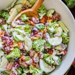 Finished broccoli grape salad in a serving bowl with mixing spoon