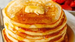 Buttermilk Pancakes stacked on a plate served with maple syrup