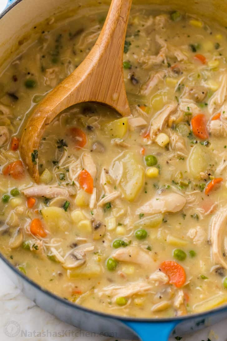 Chicken Pot Pie Soup is creamy, hearty, and delicious. This soup has all the comforts of Chicken Pot Pie without having to make a crust. Soup in a pot with ladle