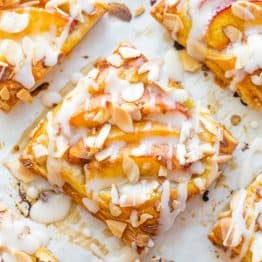 Peach tartlets with juicy peaches, toasted almonds & vanilla glaze over a flaky crust. Puff pastry peach tartlets always get RAVE REVIEWS! Easy, excellent.. | natashaskitchen.com