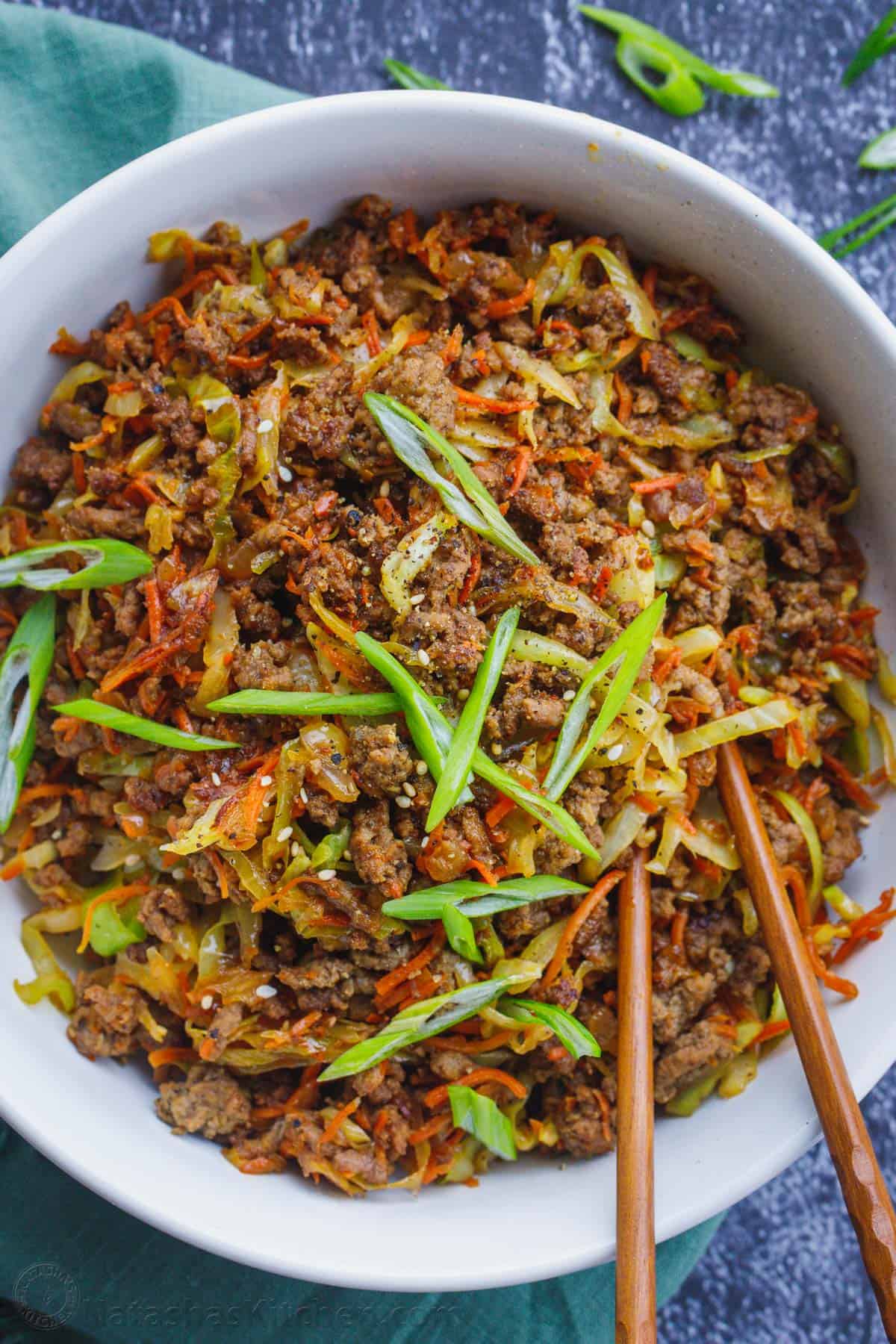 This is the easiest Asian-inspired dinner. The eggroll in a bowl is made with ground meat, vegetables and a light sauce. Egg roll bowl topped with green onion.