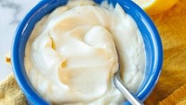Creamy Homemade Mayonnaise in a blue ramekin with a spoon.