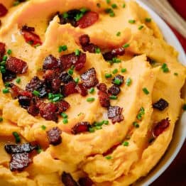 A savory mashed sweet potatoes recipe. Combining yukon and sweet potatoes is brilliant! A perfect holiday side dish. Super easy and seriously delicious. #thanksgiving #natashaskitchen #easysidedish #sweetpotatoes