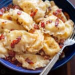 Pierogi on a plate with bacon and a fork