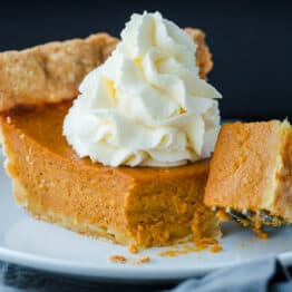 pumpkin pie on a plate with whipped cream