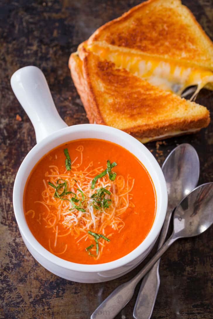 Homemade Creamy Tomato Soup is an easy 30-minute recipe. Tomato basil soup has a rich flavor profile and is balanced with cream and parmesan. Creamy tomato soup served with grilled cheese sandwich