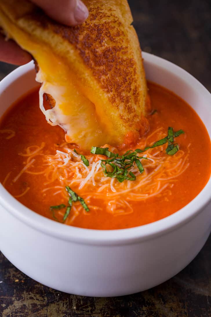 Homemade Creamy Tomato Soup is an easy 30-minute recipe. Tomato basil soup has a rich flavor profile and is balanced with cream and parmesan. Serving tomato soup with a grilled cheese sandwich