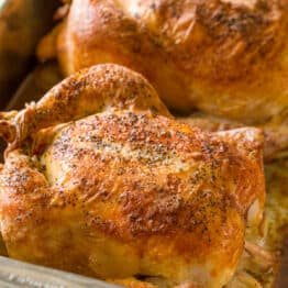 Two roasted chickens in pan